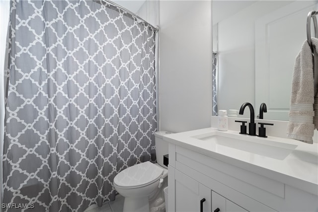 bathroom with a shower with curtain, vanity, toilet, and tile patterned floors