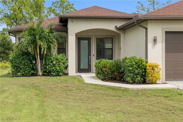 property entrance featuring a garage and a yard