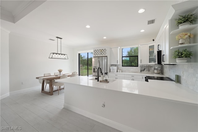 kitchen featuring pendant lighting, white cabinets, ornamental molding, tasteful backsplash, and appliances with stainless steel finishes