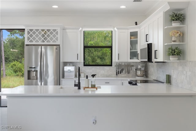 kitchen featuring a wealth of natural light, white cabinets, appliances with stainless steel finishes, and sink