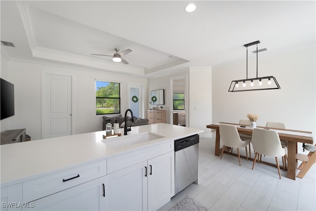 kitchen featuring pendant lighting, a tray ceiling, sink, white cabinetry, and stainless steel dishwasher