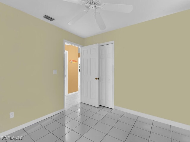 unfurnished room with ceiling fan and light tile patterned floors