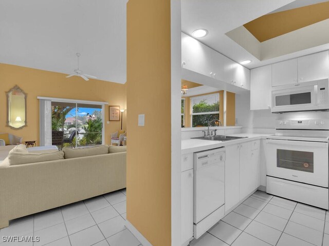 kitchen with white cabinets, sink, light tile patterned floors, and white appliances