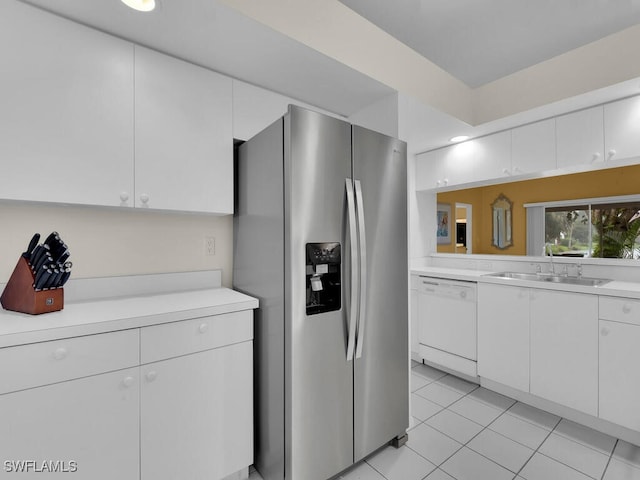 kitchen featuring light tile patterned flooring, sink, white dishwasher, white cabinets, and stainless steel fridge with ice dispenser