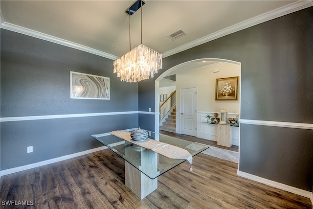 unfurnished dining area featuring hardwood / wood-style flooring, crown molding, and a chandelier