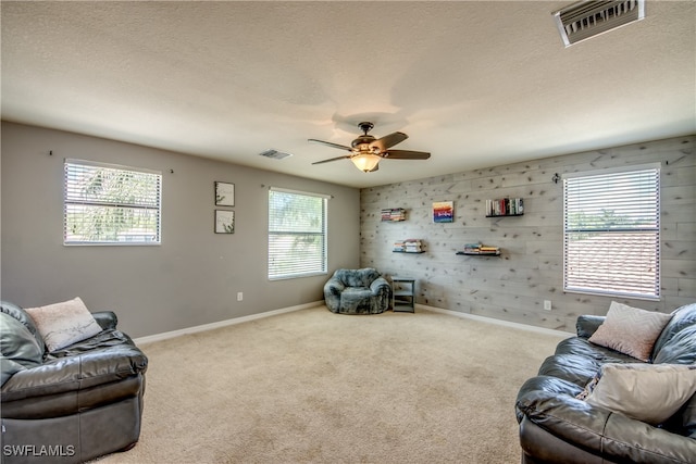 living room featuring ceiling fan, carpet floors, and a healthy amount of sunlight