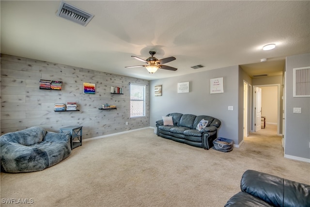 living room featuring ceiling fan, carpet floors, and a textured ceiling