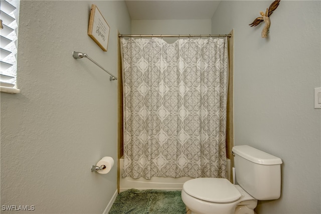 bathroom with shower / bath combination with curtain and toilet