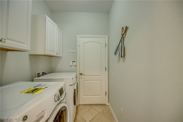 washroom featuring cabinets, independent washer and dryer, and light tile patterned floors