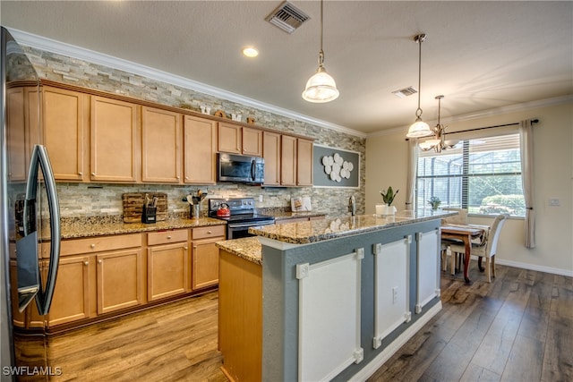 kitchen with hanging light fixtures, light hardwood / wood-style flooring, appliances with stainless steel finishes, a notable chandelier, and light stone countertops