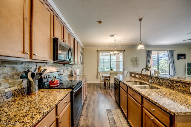 kitchen featuring dark hardwood / wood-style flooring, black appliances, ornamental molding, sink, and a chandelier