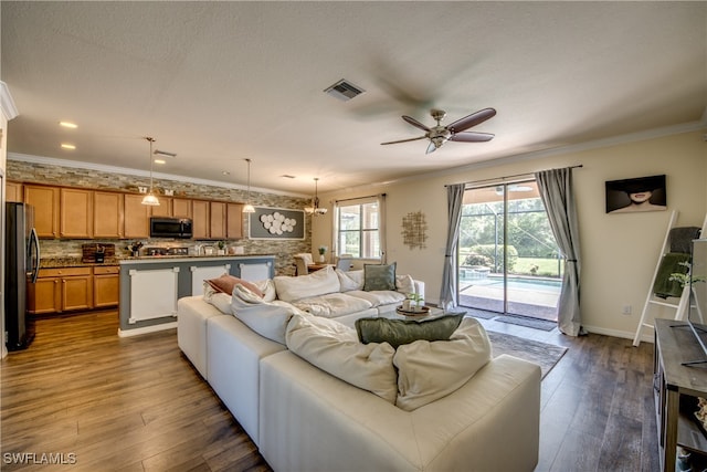 living room featuring a textured ceiling, ceiling fan with notable chandelier, ornamental molding, and dark hardwood / wood-style flooring