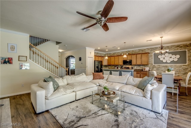 living room with ornamental molding, ceiling fan with notable chandelier, and hardwood / wood-style floors