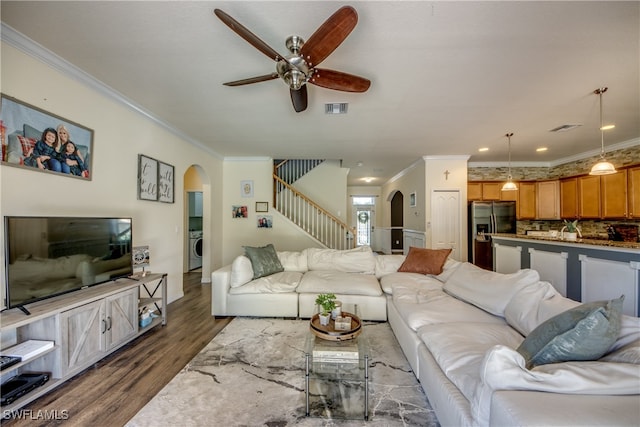 living room with ceiling fan, crown molding, dark wood-type flooring, and washer / dryer