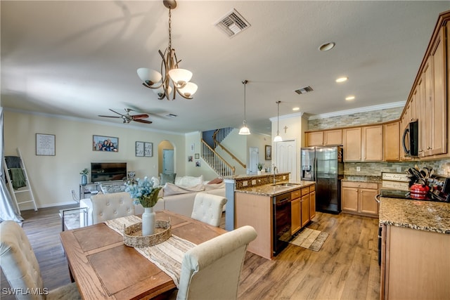 dining space with ceiling fan with notable chandelier, crown molding, sink, and light hardwood / wood-style flooring