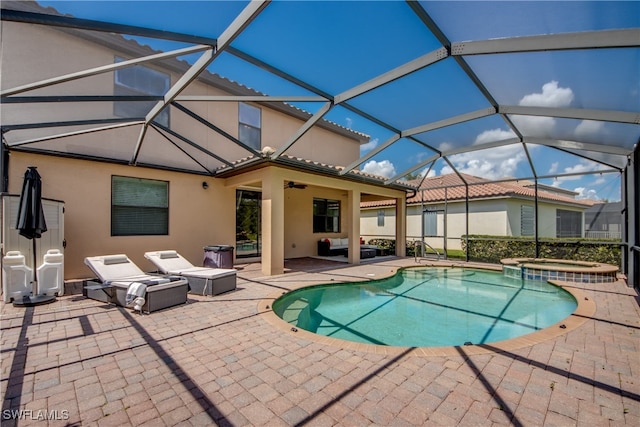 view of pool with a lanai, an in ground hot tub, and a patio area