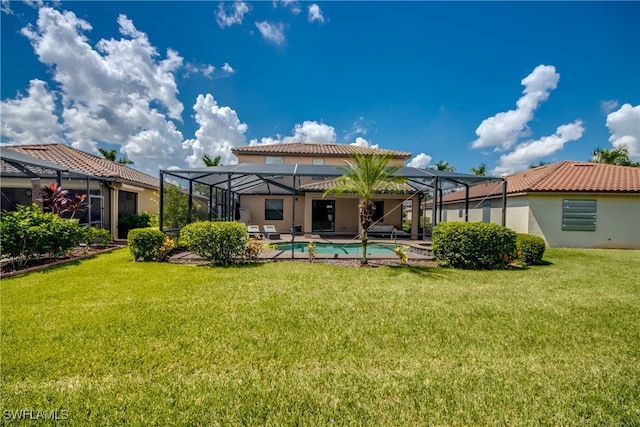 rear view of property with a lanai and a yard