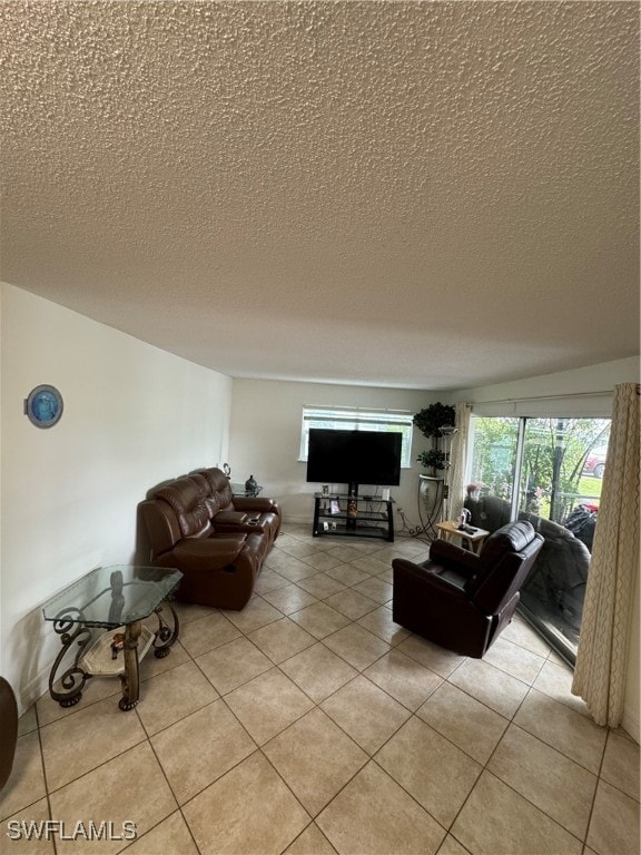 living room with a textured ceiling and light tile patterned floors