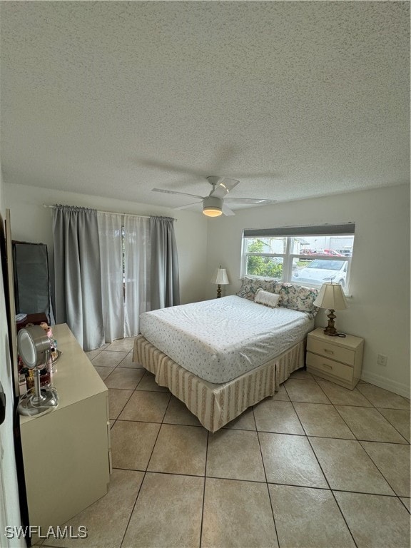 tiled bedroom with a textured ceiling and ceiling fan