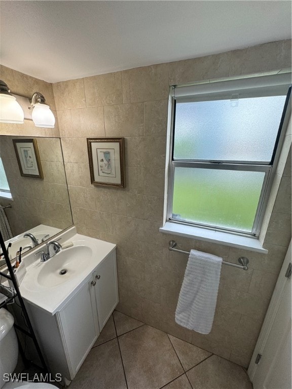 bathroom featuring vanity, toilet, tile walls, and tile patterned flooring