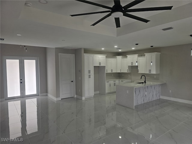 kitchen with a tray ceiling, white cabinets, kitchen peninsula, and french doors