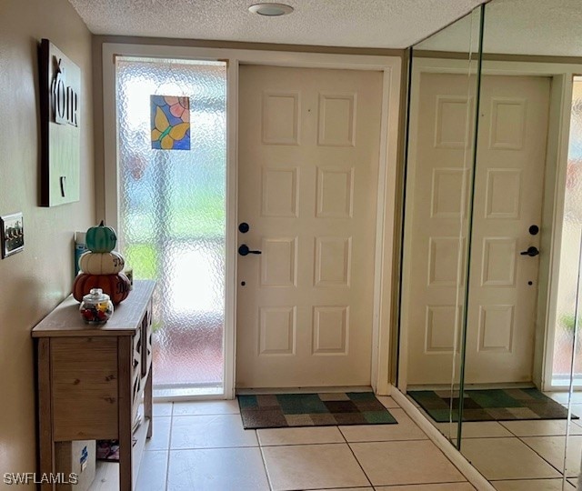 tiled foyer entrance with a textured ceiling