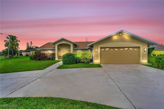 ranch-style house featuring a garage and a yard