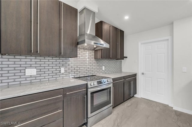 kitchen featuring tasteful backsplash, light stone counters, dark brown cabinets, wall chimney range hood, and stainless steel electric range