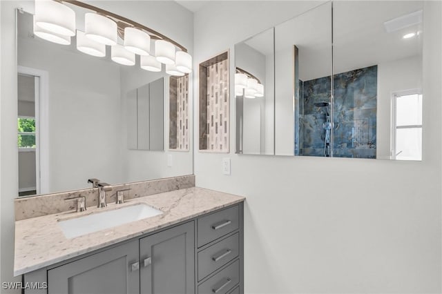 bathroom with plenty of natural light, vanity, and tiled shower