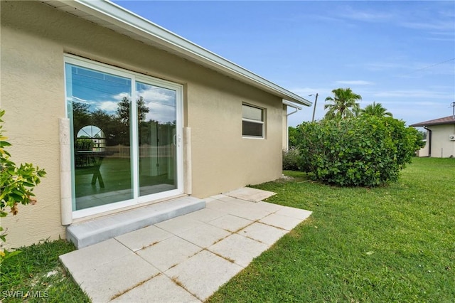 view of side of property featuring a yard and a patio