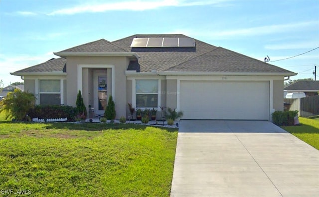 view of front of home with a front yard, a garage, and solar panels