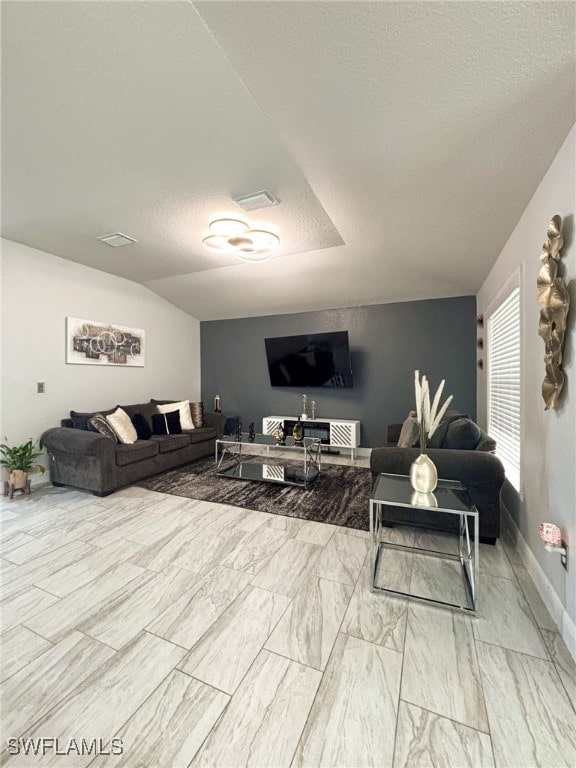 living room featuring a textured ceiling and lofted ceiling