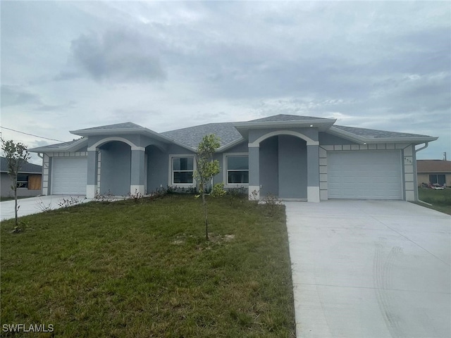 ranch-style house featuring a garage and a front lawn