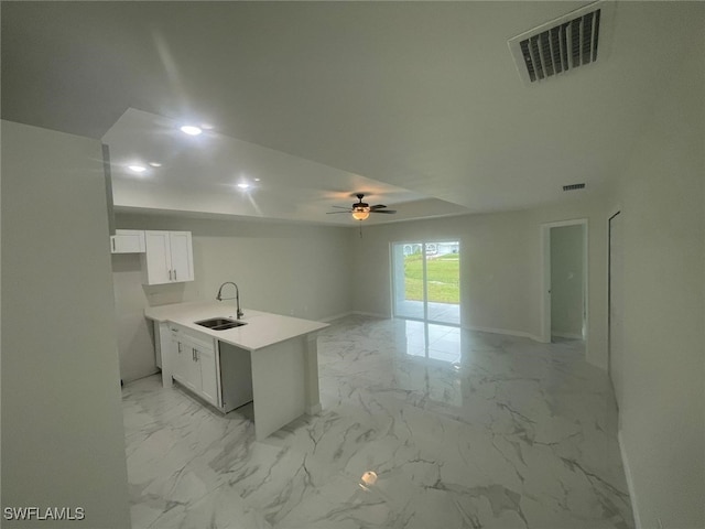 kitchen with white cabinets, kitchen peninsula, sink, and ceiling fan