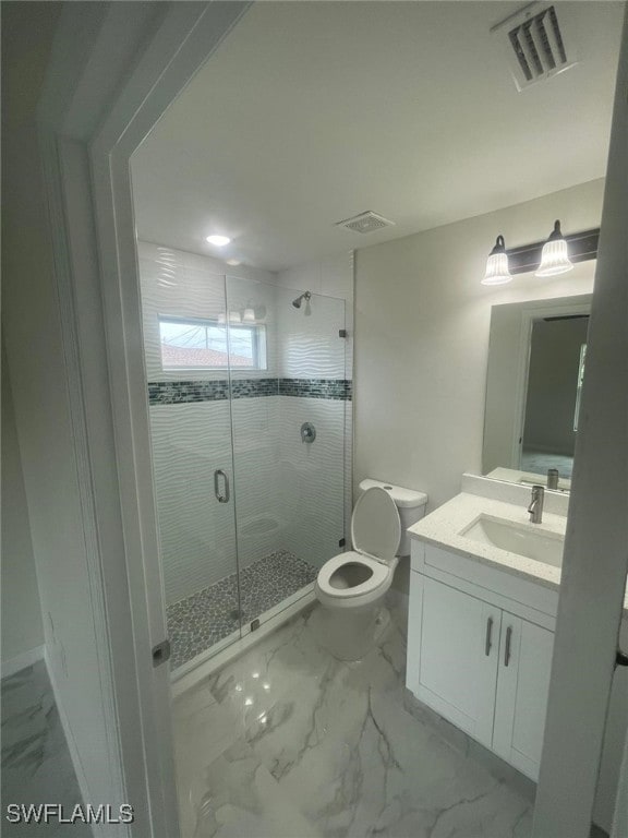 bathroom featuring a shower with shower door, vanity, and toilet