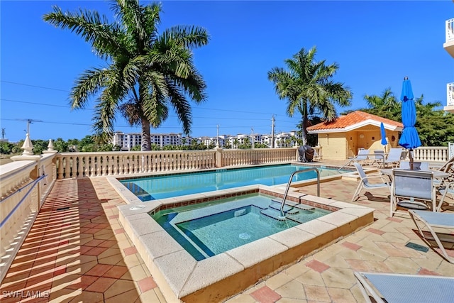 view of pool with an outbuilding, an in ground hot tub, and a patio area