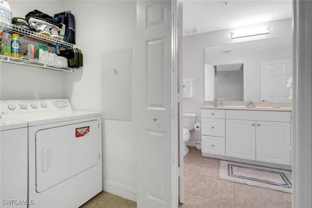 laundry room with sink, light tile patterned floors, and independent washer and dryer