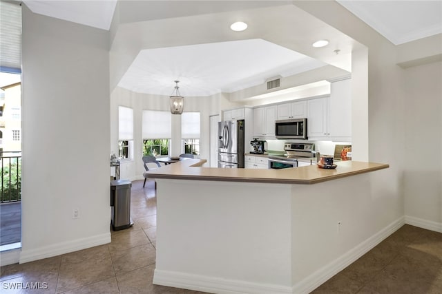 kitchen featuring white cabinets, light tile patterned flooring, kitchen peninsula, decorative light fixtures, and stainless steel appliances