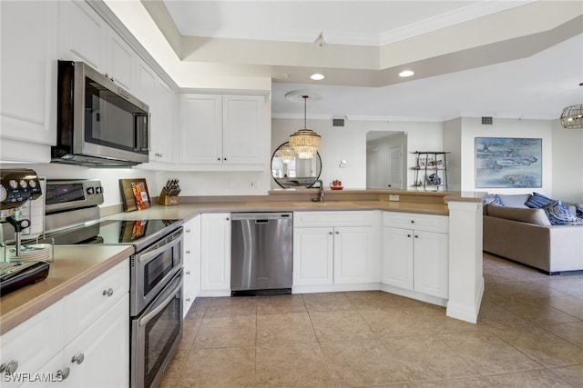 kitchen with stainless steel appliances, white cabinets, decorative light fixtures, and sink