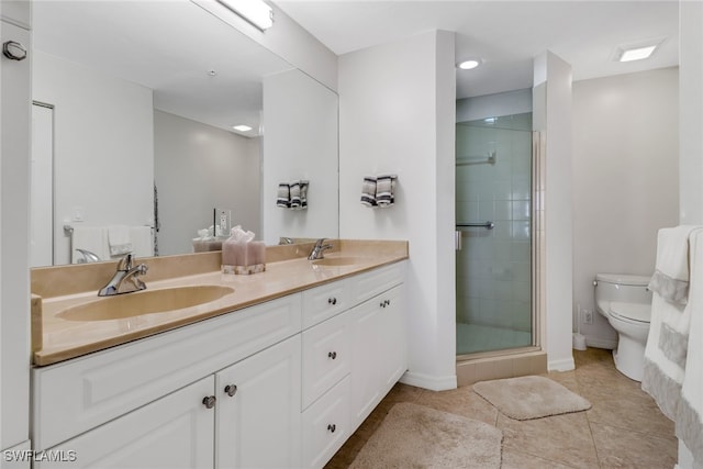 bathroom featuring vanity, toilet, tile patterned floors, and a shower with shower door