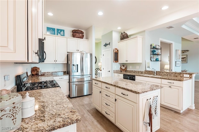 kitchen featuring sink, black appliances, a center island, light stone countertops, and light hardwood / wood-style floors