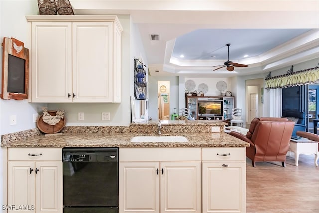 kitchen featuring a raised ceiling, black dishwasher, sink, and ceiling fan