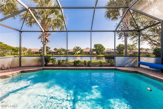 view of swimming pool with glass enclosure and a water view