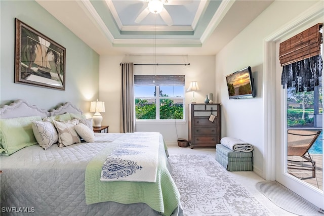 carpeted bedroom with ceiling fan, ornamental molding, a raised ceiling, and access to exterior