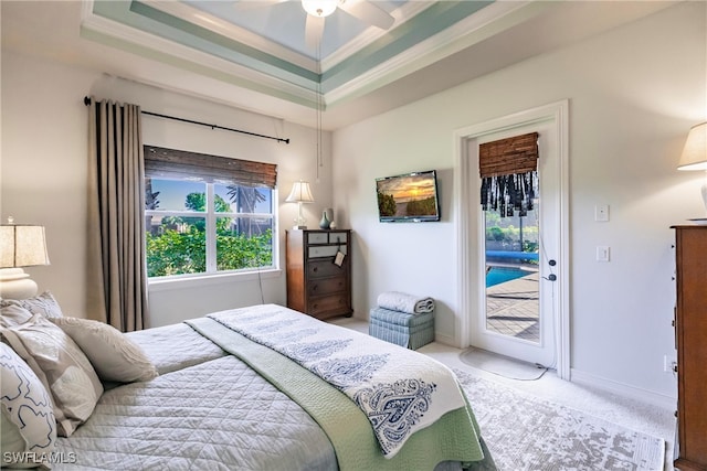 bedroom featuring a tray ceiling, carpet flooring, access to outside, ornamental molding, and ceiling fan