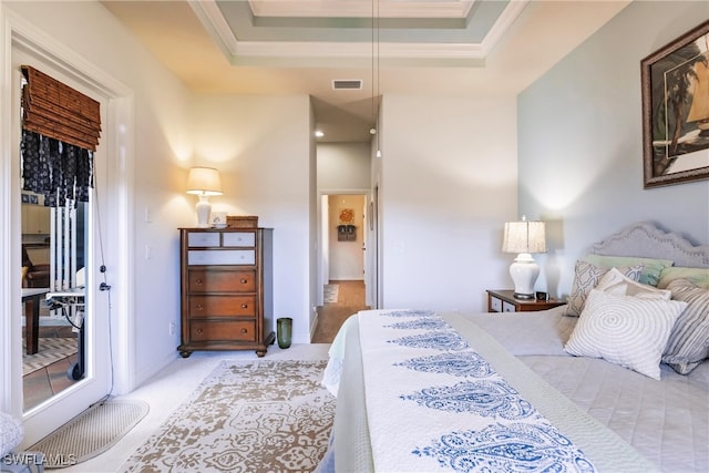 carpeted bedroom featuring crown molding and a tray ceiling