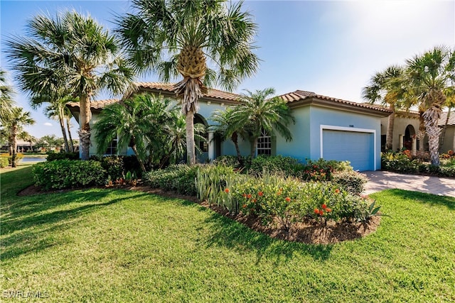 mediterranean / spanish house with a front yard and a garage