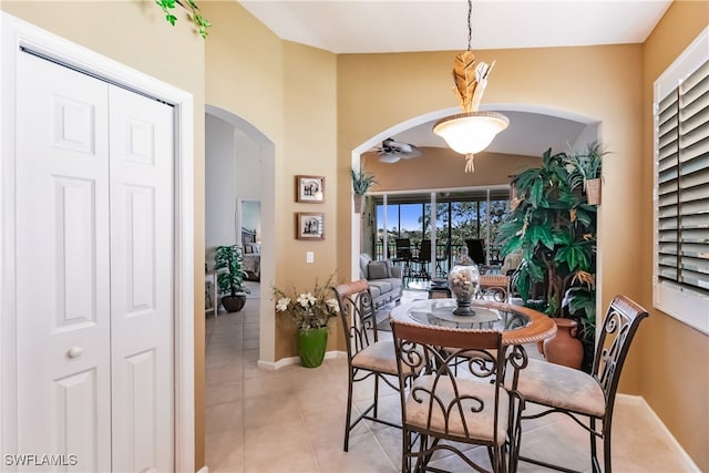 dining space featuring light tile patterned flooring and vaulted ceiling