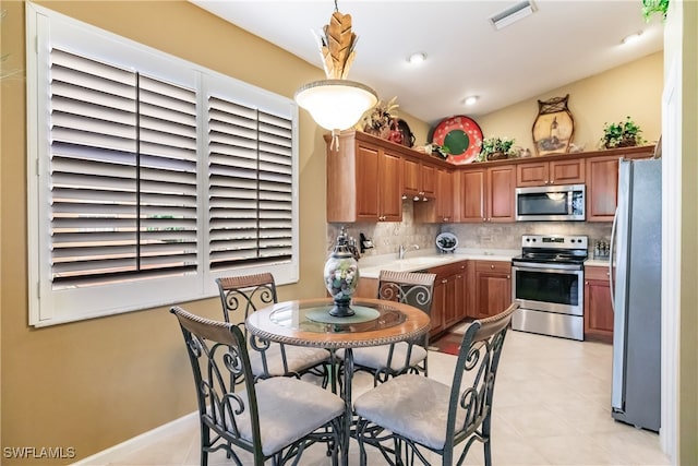 kitchen featuring decorative backsplash, stainless steel appliances, light tile patterned flooring, and sink