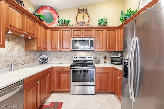 kitchen with lofted ceiling, light tile patterned floors, sink, backsplash, and stainless steel appliances